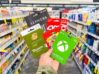 hand holding gift cards from panera, sephora, amc, nintendo, xbox