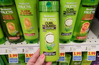 hand holding a bottle of garnier fructis shampoo at kroger