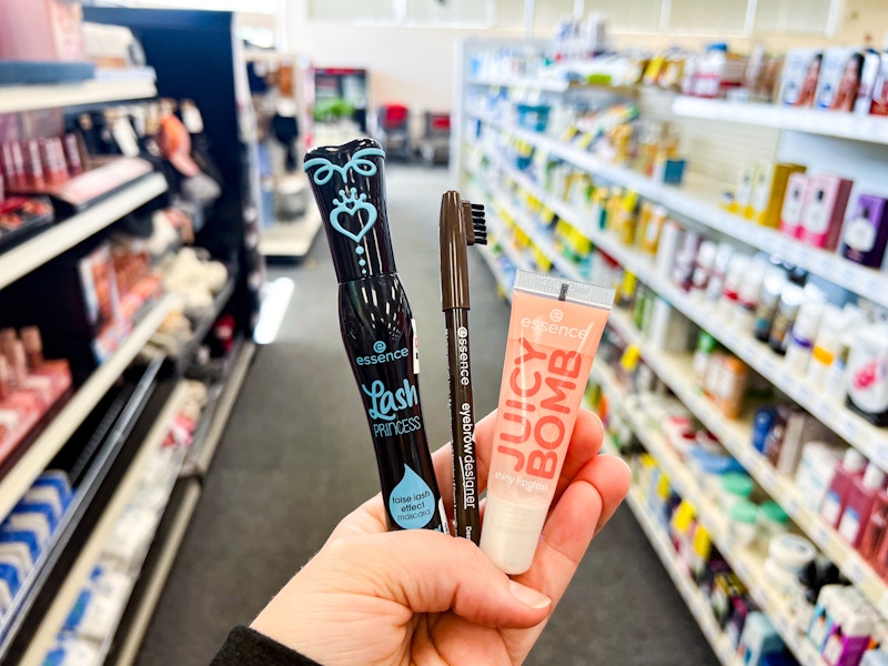 hand holding three essence cosmetics products