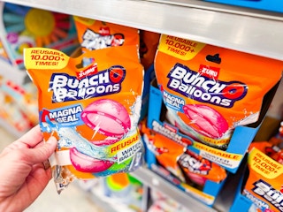 hand holding bag of bunch o balloons reusable water balloons near walmart shelf