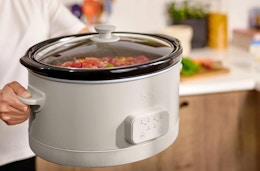 a person holding a slow cooker