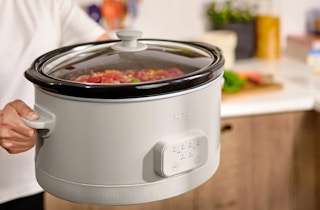 a person holding a slow cooker