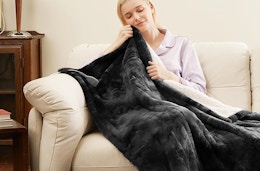 a person on a couch un an electric blanket