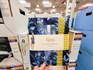 hand holding a set of blue satin pajamas with flowers