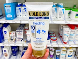 hand holding a bottle of gold bondy healing hand cream at target
