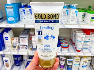 hand holding a bottle of gold bondy healing hand cream at target