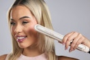 a woman using a flat iron