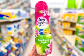 hand holding a container of laundry scent boosters in store aisle