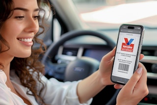 a woman pulling up a valvoline instant oil change coupon on her phone while sitting in her car