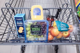 crackers, grapes, cheese, fruit spread, and apples in a cart
