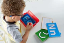 lifestyle image of a child tracing letters on a sensory pad