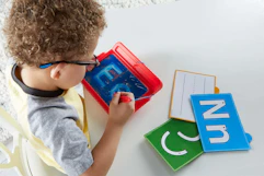 lifestyle image of a child tracing letters on a sensory pad