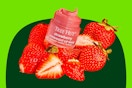 A Tree Hut Overnight Lip Mask in strawberry flavor among a bunch of strawberries