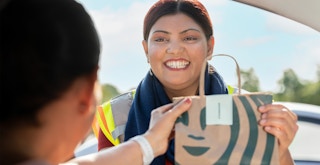 A customer picking up their Starbucks order at the Target drive up