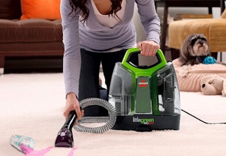 Woman vacuuming with the bissell little green machine