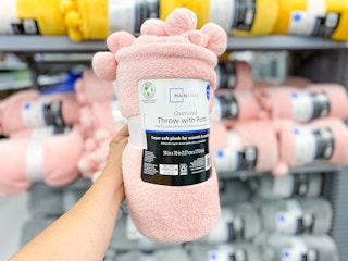 holding up wrapped blanket in front of store shelf