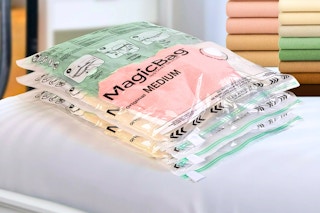 Lifestyle image of vacuum MagicBags with folded sheets in the background