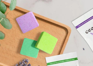 three colorful square shower steamer on a wooden tray