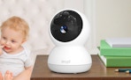 a security camera on a desk next to a baby
