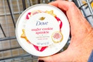 hand holding a jar of dove body scrub