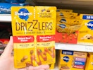 hand holding pedigree drizzlers in front of a target shelf
