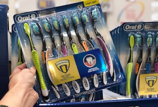 someone holding up a 8 pack of oral b toothbrushes