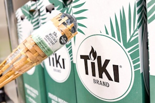 hand holding a tiki torch in front of a target display