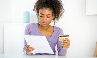 person holding credit card and looking at credit score