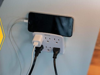 Wall adapter with cords and a phone on top
