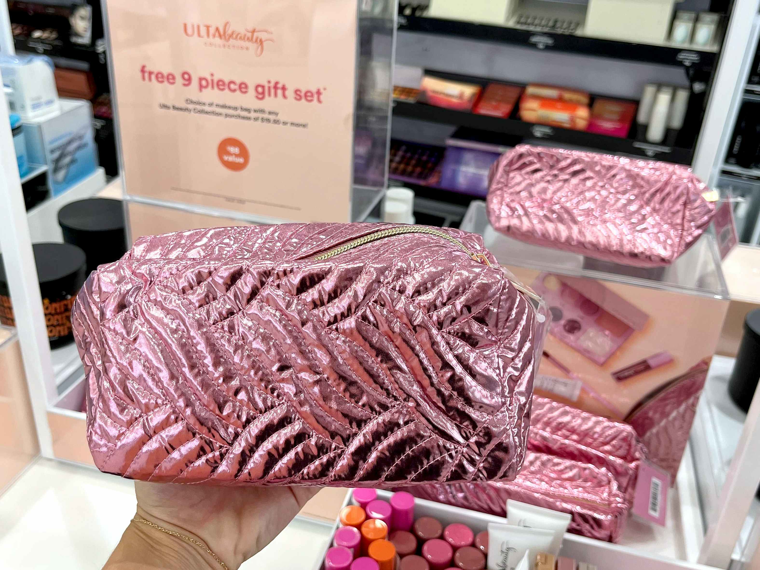 hand holding pink makeup bag with gift set at ulta