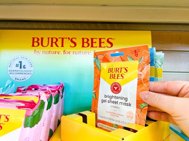 person grabbing a burt's bees sheet mask out of the display box