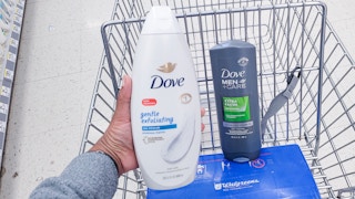 hand holding bottle of dove body wash with a bottle of dove body wash in shopping cart