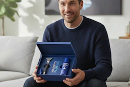 a man holding the harry's plus gift set