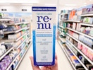 hand holding renu contact solution in aisle