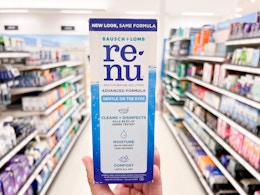 hand holding renu contact solution in aisle