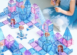 a kid playing with purple and blue magnetic tiles