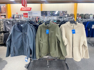 A variety of Columbia jackets hanging on a racks.