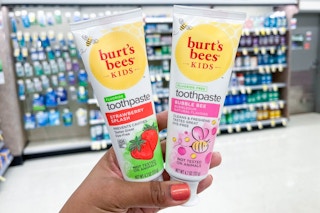 hand holding two tubes of burt's bees kids toothpaste