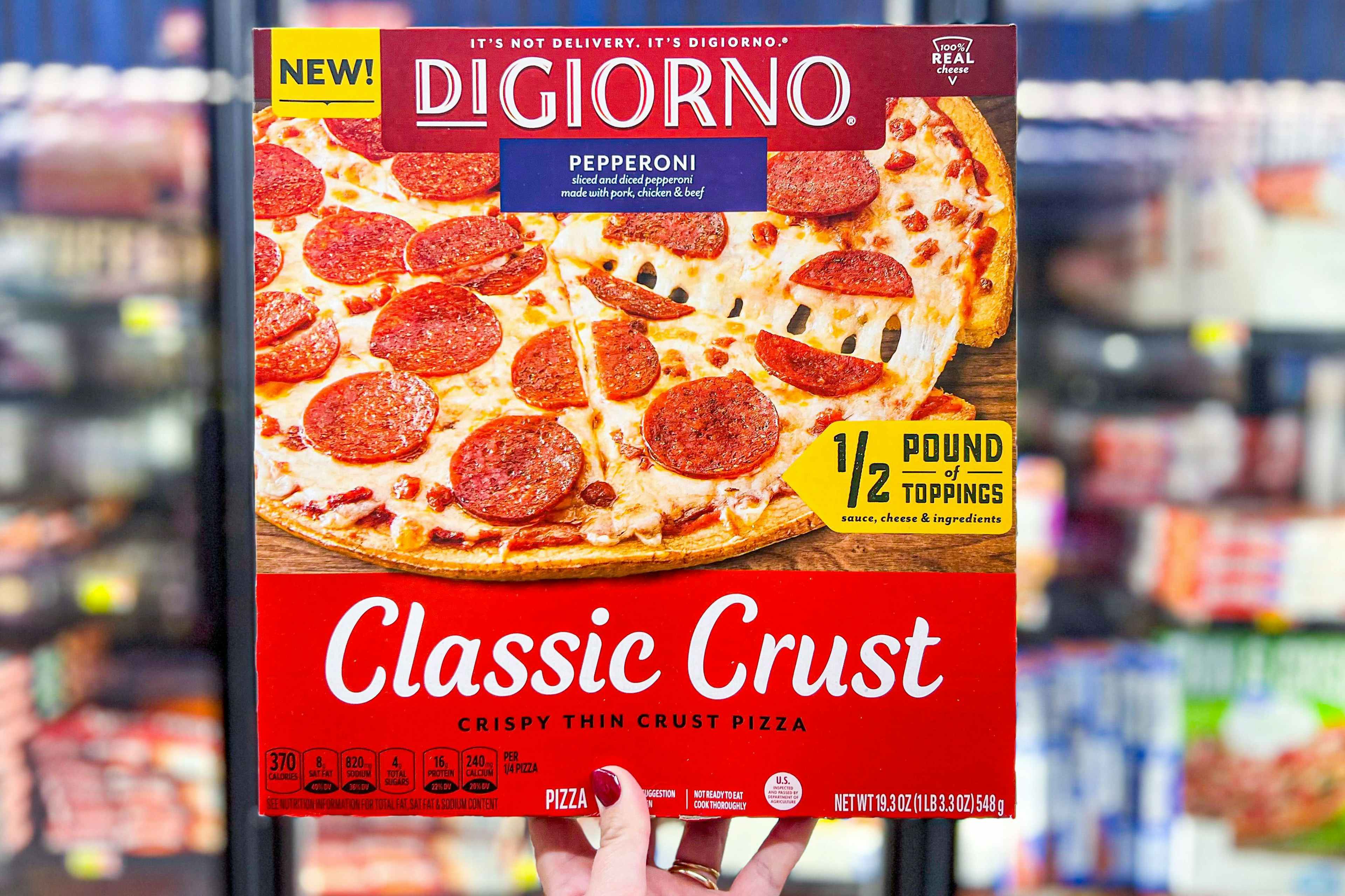 someone holding up a digiorno classic crust pizza at walmart