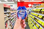 person holding a container of tums chewy bites in an aisle