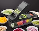 a vegetable chopper surrounded by cut vegetables in bowls