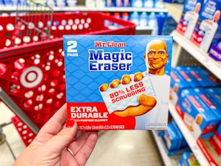hand holding a mr clean magic eraser in front of a target cart
