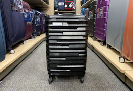a spinner luggage in the middle of a store's aisle 