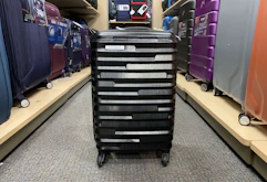 a spinner luggage in the middle of a store's aisle
