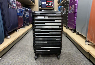 a spinner luggage in the middle of a store's aisle