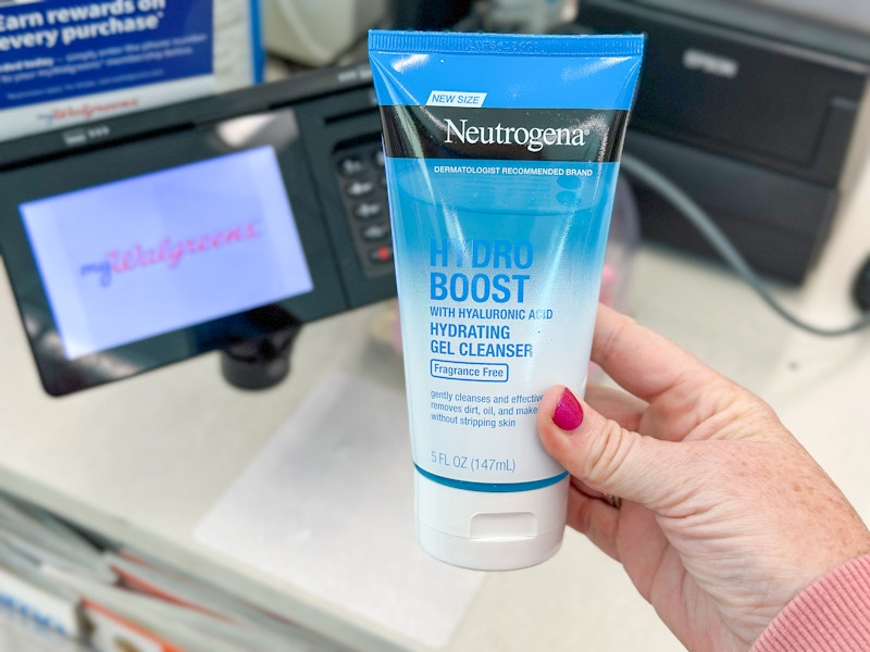 person holding neutrogena cleanser by the checkout at walgreens