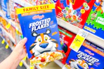 person holding a box of frosted flakes cereal