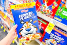 person holding a box of frosted flakes cereal
