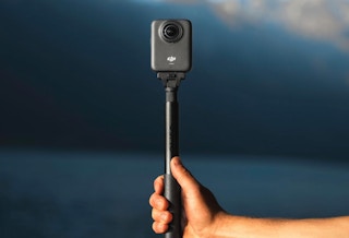 a person holding a vlogging camera on a tripod