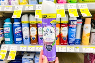 hand holding a can of glade air freshener spray in a store aisle